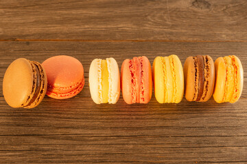 colorful macarons in a row of a wooden table