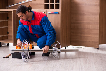 Young handsome male carpenter working indoors
