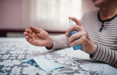 Keep your hands clean. Woman disinfects hands with sanitizer spray against viruses, close up photo. Health care concept