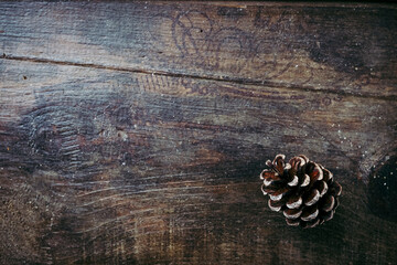 Fond en bois vieilli avec une pomme de pin dans un angle - Arrière plan ambiance saison d'hiver...