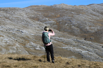 Woman hiker taking photos of mountain 