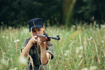 Woman on nature Shelter with weapons in hand hunting black cap 