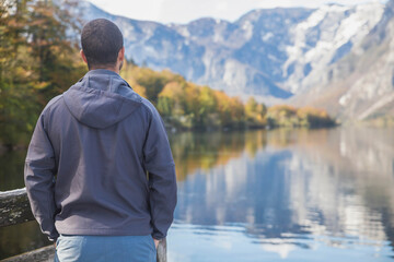 Naklejka na ściany i meble A man stands near Lake Bohinj in Slovenia with his back turned