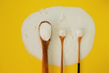 Baking soda.Sodium bicarbonate on a wooden spoon set on a yellow background.Food supplement. Organic hypoallergenic cleaning agent.Zero waste concept