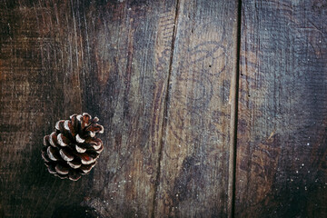 Fond en bois vieilli avec une pomme de pin dans un angle - Arrière plan ambiance saison d'hiver...