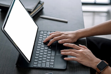 Close up. Woman office worker typing on digital tablet on desk office.