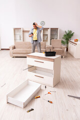 Fototapeta premium Young male carpenter repairing furniture at home
