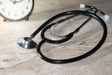 Metal stethoscope with clock on table.