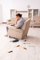 Young male carpenter repairing furniture at home