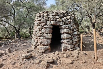 Ruins of a nuragic hut in the Santa Cristina archaeological park. Sardinia, Italy