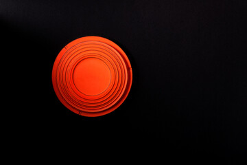 Clay disc target for skeet shooting against the black background. Half lit effect. Copy space - 394412815
