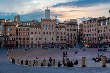 Fototapeta premium Old houses in historic centre in Siena. The Duomo Santa Maria Assunta (Cathedral of Siena) is located on the highest point of the city hill, Tuscany, Italy.