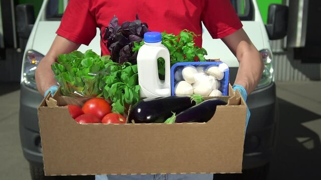 Volunteer Hold Box With Food, Social Help Spbd. Closeup Of Man Hand With Box Of Vegetables Donation. Concept Coronavirus, Food Bank. Charity Package On Car Truck Background. Outdoor Foodstuff