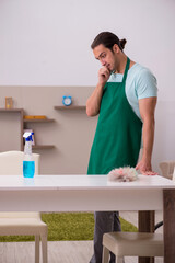 Young male contractor cleaning the house