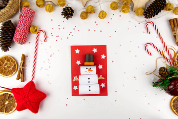 DIY step-by-step instructions for a Christmas card with children. Volumetric snowman on a postcard made of colored paper, glue and scissors. The finished result.