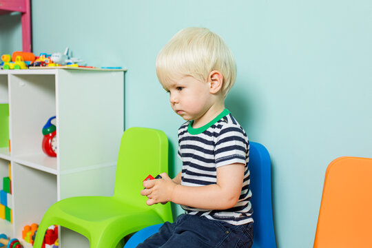 The little boy abandoned by everyone is sitting in the playroom