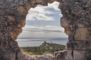 View of the Sant'Elia promontory from arched window of the Sant'Ignazio Fort. Cagliari, Sardinia, Italy