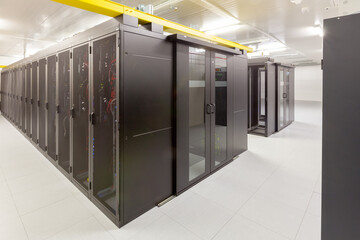 Network servers in a data center. Tier III carrier neutral data center. Server rooms.