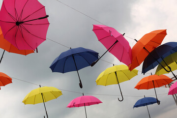 Fototapeta na wymiar Yellow, pink, blue and red color umbrellas on sky background.
