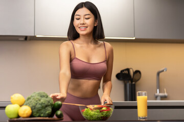Fit Asian Woman Cooking Salad Slimming And Dieting In Kitchen