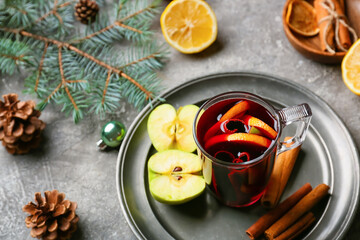 Glass cup of tasty mulled wine on grunge background