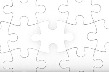 White jigsaw puzzle pattern background. placing last piece of jigsaw puzzle