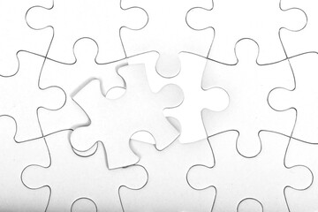 Obraz premium White jigsaw puzzle pattern background. placing last piece of jigsaw puzzle