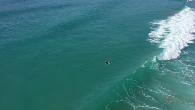 Aerial view of surfer duck-diving under a big wave in El Palmar, Spanish atlantic coast
