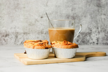 A picture of freshly baked 3 egg tarts with milk coffee on wooden board.