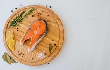 Top view of salmon steak on wooden plate with copy space on the right. Cooking concept
