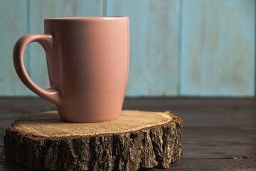 A pink cup on a wooden stump