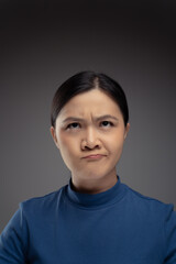 Close up shot of confused Asian woman look up with copy space.