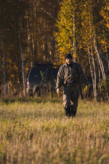 Male hunter in camouflage clothes ready to hunt with hunting rifle