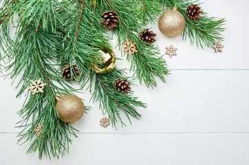 Green pine tree branches with christmas decorations on white background