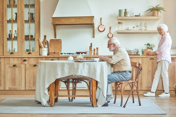 Happy elderly couple spending time together in the kitchen