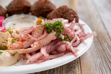 A view of a side of sumac onions, part of a falafel entree plate.