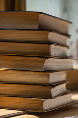 Fototapeta premium stack of old books lies on the background of a window on a sunny day.