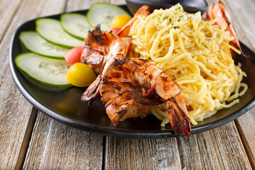 A view of a plate of garlic noodles and shrimp.