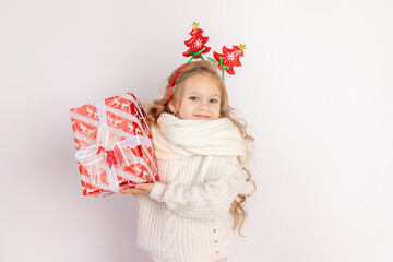 baby girl holding red gift on white isolated background, space for text