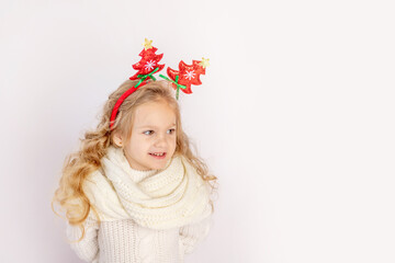 happy child girl in the Christmas sweater and headband isolated on white background, space for text, concept of new year and Christmas