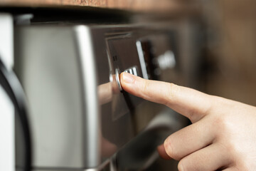Young woman pushing the buttons on the dishwasher