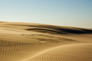 Krajobraz pustynny błękitne niebo i ruchome piaski w pięknym świetle zachodzącego słońca	
