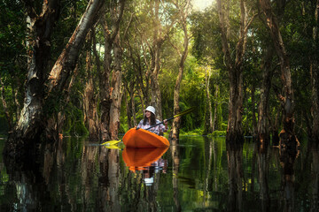 Asian traveler woman kayaking in Mangrove forest of Botanical Garden, Thailand. Landscape travel and tourist concept. - 394424094