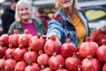 Woman reaches for a pomegranate