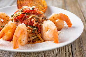 A view of a plate of angel hair pasta with shrimp.