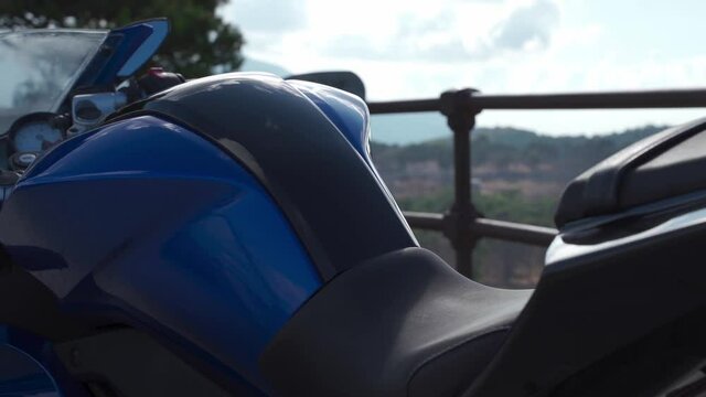 Motorcycle saddle slow motion, blue yamaha r125, motorcycle with sea and sky background, on a mountain