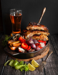 Pork ribs with vegetables and beer. Men's food