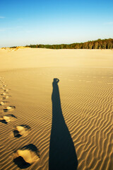 Krajobraz pustynny błękitne niebo i ruchome piaski w pięknym świetle zachodzącego słońca z cieniem sylwetki na piasku