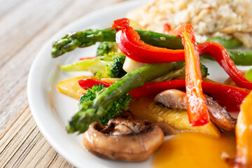A closeup view of a side of grilled vegetables, featuring mushrooms, asparagus and bell peppers.