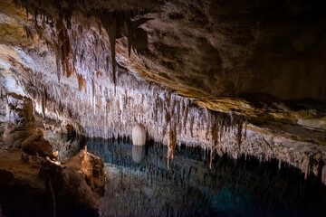 stalagmites and stalactites and an underground lake in the Drach Caves in Palma de Mallorca, Balearic Islands, Spain
